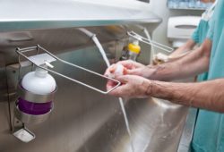 two doctors in scrubs washing hands