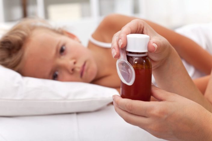 child lying in bed waiting to take medicine