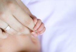 close-up of infant’s hand holding mother’s finger