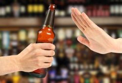 hand rejects a bottle of beer in a bar