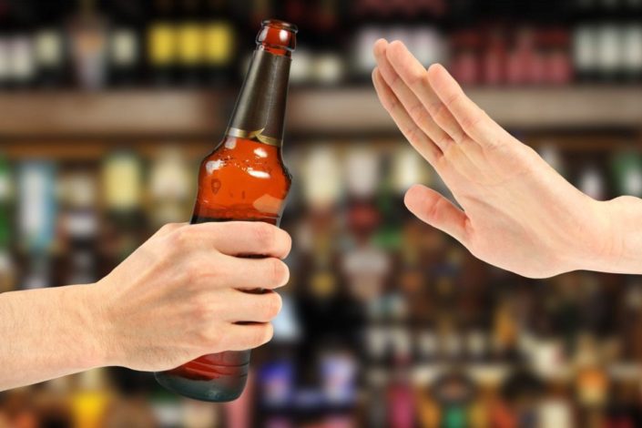 hand rejects a bottle of beer in a bar