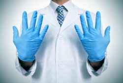 A doctor wearing blue latex gloves