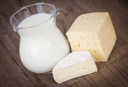 Milk and cheese on a table. Lactose intolerance is a condition that causes stomach discomfort. It’s your body reacting to the sugar in milk (or other dairy).
