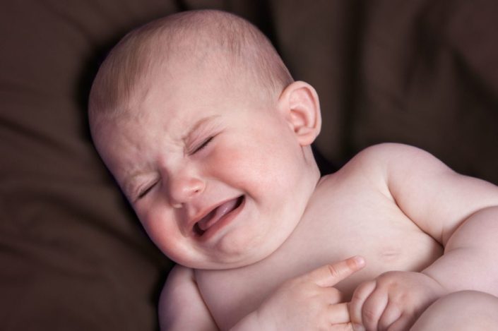 close-up of a crying baby in distress