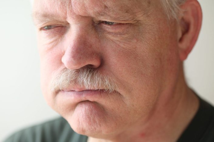 A senior man experiences bloating and reflux from indigestion.