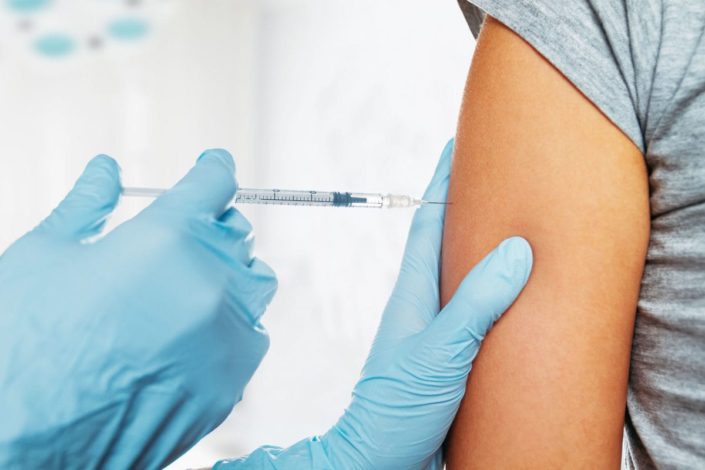 Woman receiving injection in upper arm
