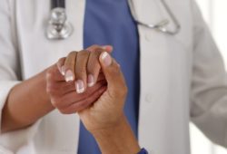 Close-up doctor holding female patient’s hand