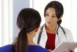 A woman talking to her doctor about bleeding. Abnormal uterine bleeding is heavy or unusual bleeding from the uterus (through the vagina). Vaginal bleeding between periods is a symptom.