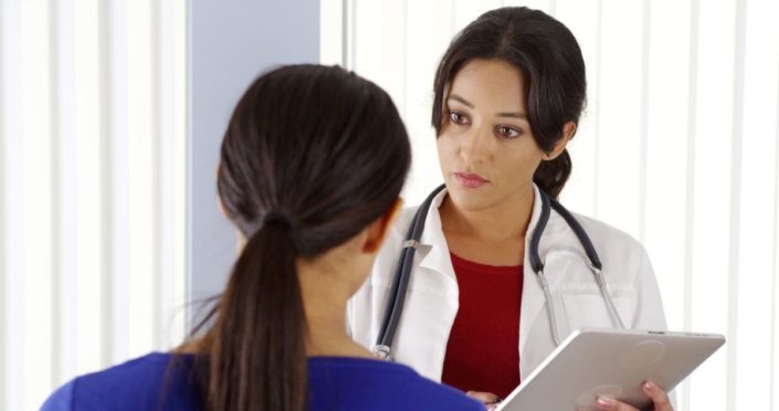 A woman talking to her doctor about bleeding. Abnormal uterine bleeding is heavy or unusual bleeding from the uterus (through the vagina). Vaginal bleeding between periods is a symptom.