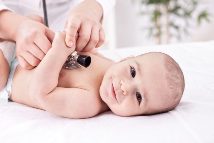 doctor listens to a baby’s heart with a stethoscope