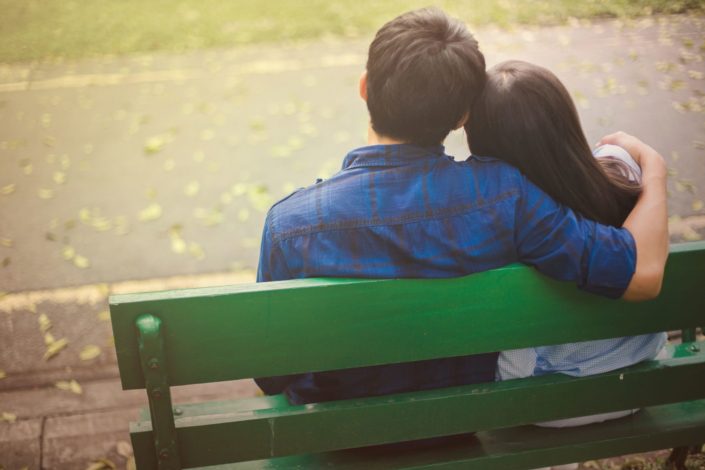 couple sit and embrace in the garden