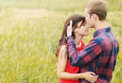 sensual outdoor portrait of young attractive couple in love kissing in summer field