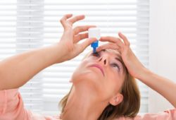 woman putting drops in her eye