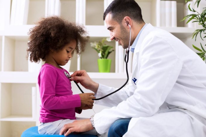 Doctor listens to young girl’s heartbeat