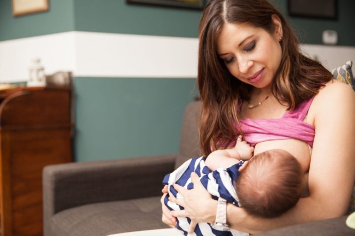 a mother breastfeeds her baby