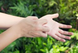 Man scratching an itch on his wrist