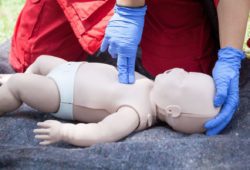 Person doing CPR on baby dummy during first-aid training