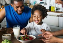 A father and son enjoy a healthy meal together as part of a healthy lifestyle.