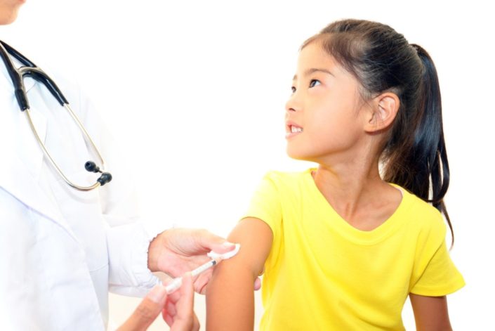 A young girl receives the measles vaccine from a doctor. Measles is a very contagious respiratory illness that also causes a fever and a rash. It is preventable with a vaccine.