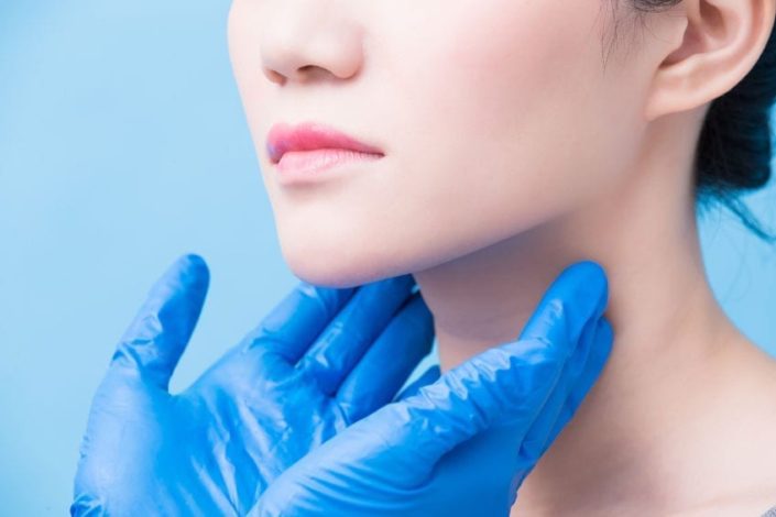 two hands wearing rubber gloves and feeling a woman's lymph-nodes in her neck to test for non-hodgkin lymphoma