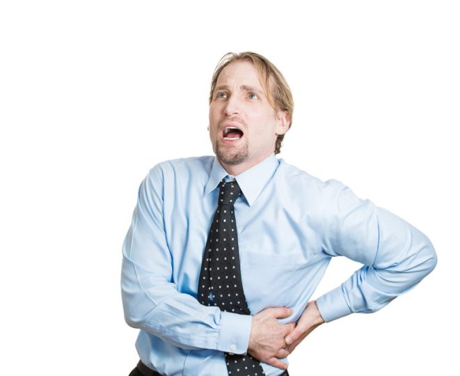 Close-up of a young businessman holding side with kidney pain