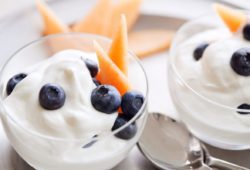A photo of creamy yogurt sprinkled with blueberries and cantaloupe