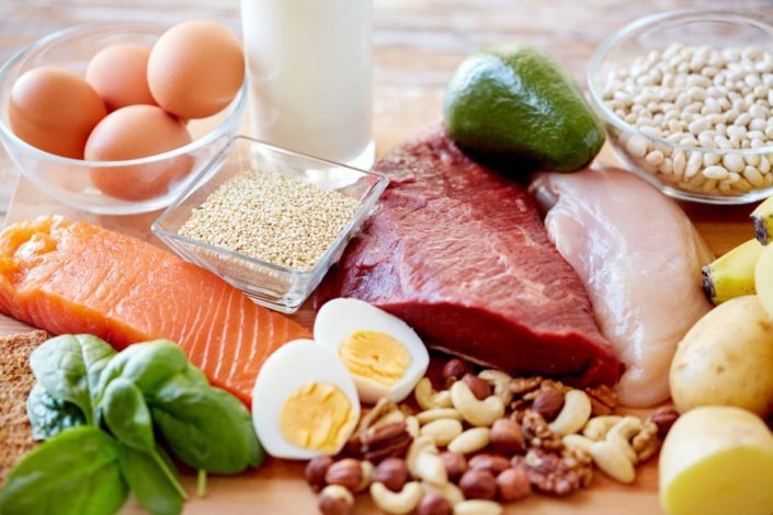 Close-up of different nutrient-rich foods, such as lean meat, fish, dairy, whole grains, and vegetables and fruits