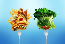 Choosing between a fork with greasy, cholesterol-rich food or a fork with fresh, healthy vegetables and fruits.