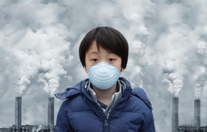 Boy wearing mouth mask surrounded by air pollution