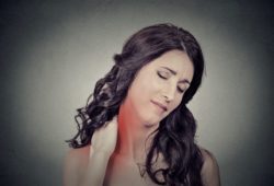 Young woman massaging neck, which is in pain