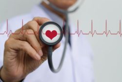 Doctor wearing a stethoscope “listening” to an electrocardiogram (EKG)