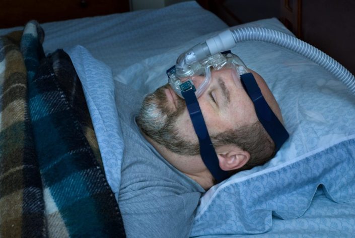 Man sleeping on back with nasal mask.