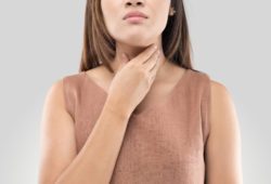 Woman touching her throat because it is sore