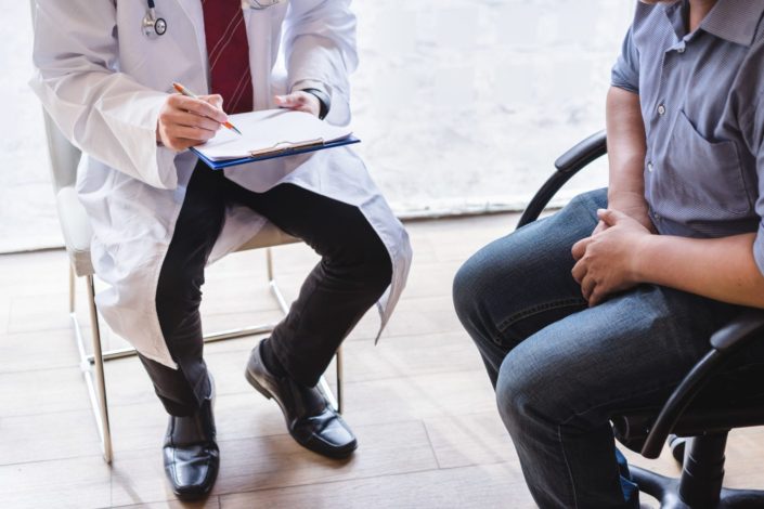 Male doctor and testicular cancer patient are discussing about testicular cancer test report.