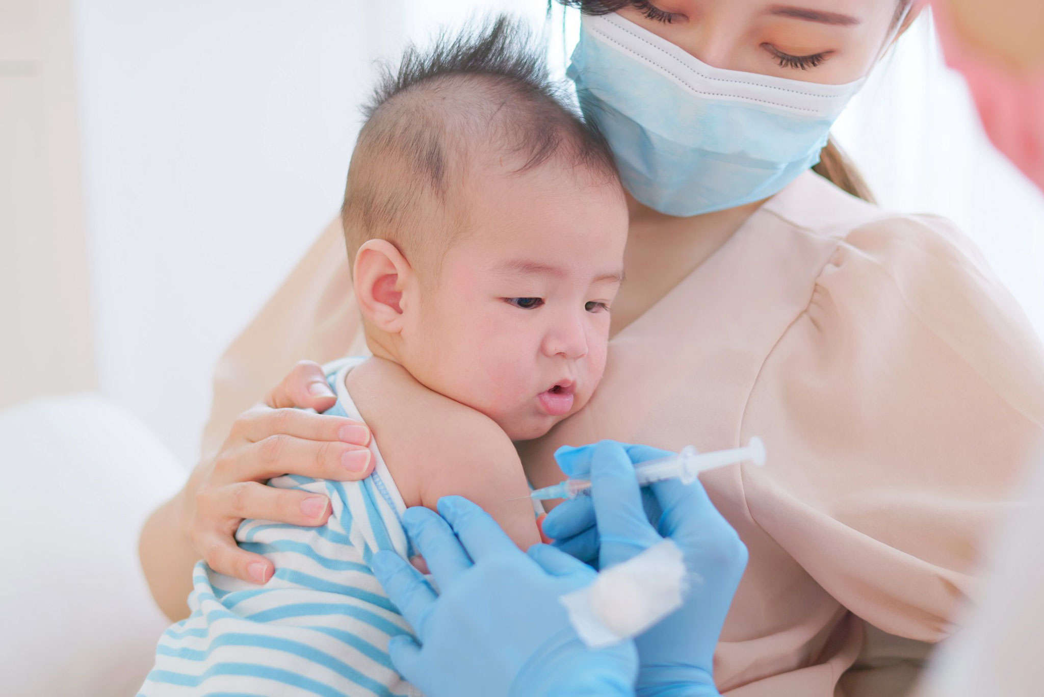 Mother holds her baby as she's vaccinated by her doctor. A new study shows a possible association between exposure to aluminum in some childhood vaccinations and asthma in young children.